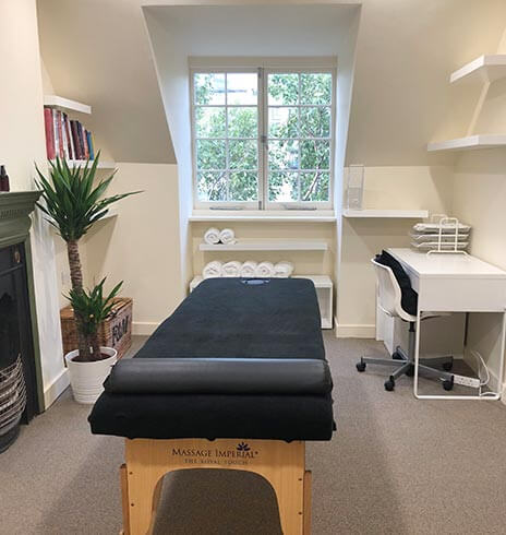 Treatment room with massage bed and desk